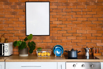 Wooden counters with electric stove, utensils and houseplant in modern kitchen