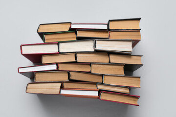 Many stacked books on grey background