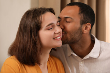 Romantic date. Guy kissing his girlfriend indoors