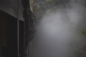 Melbourne Suspension Train, railway. Feet out of the train, smoke and cars. Australia, Belgrave