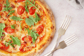 Tasty pizza Margarita with tomatoes and arugula on white table