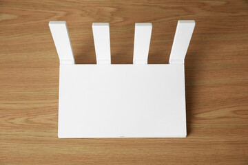 New modern Wi-Fi router on wooden table, above view
