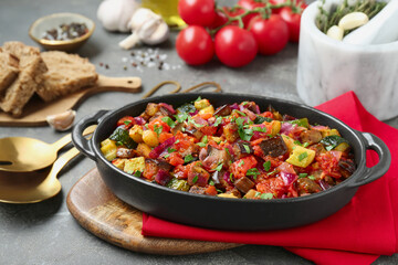 Dish with tasty ratatouille on grey textured table