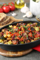 Dish with tasty ratatouille on grey textured table, closeup