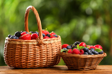 Fototapeta na wymiar Different fresh ripe berries on wooden table outdoors