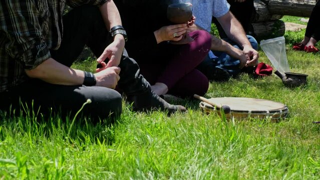 Meditative moments with people seated in circle in nature, smoky herbs and sunny day