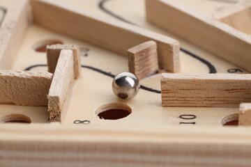 Wooden toy maze with metal ball, closeup