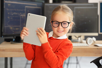 Cute little programmer girl with tablet computer in office