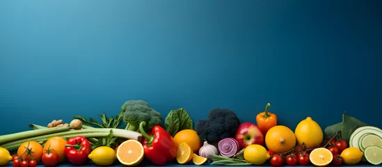 Fotobehang A banner of bright fruits and vegetables on a lively blue background with ample space for text or design elements, © Ash