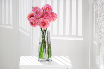 Vase of beautiful pink dahlias on stepladder in living room