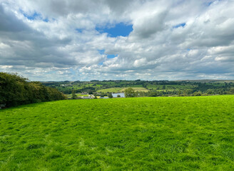 Rural landscape near, Bank Lane, with extensive fields, a reservoir, with hills, and farms in the distance near, Silsden, UK