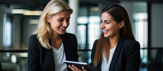 Young businesswomen collaborating Female executives meeting using tablet pc and smiling