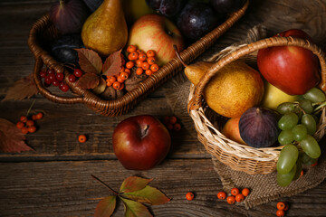 Wicker baskets with different fresh fruits on wooden background