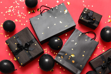Gift boxes with shopping bags and balloons on red background. Black Friday sale