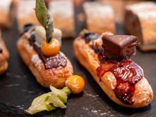 Éclair with Cream Filling, Chocolate Drizzle, and Physalis Garnish