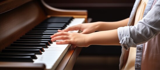 Mother teaches son piano Boy excels at keyboard Child learns music Women and children play keys...