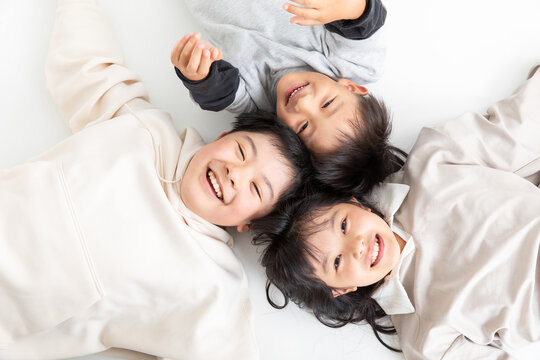 笑顔で寝転がる子ども　three brothers