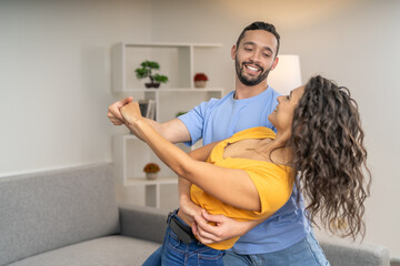 Romantic scene of a happy couple dancing at home - obrazy, fototapety, plakaty