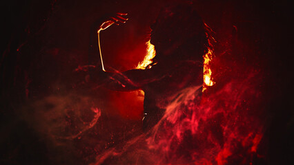 Fire dance. Body performance. Sensual artistic woman silhouette moving in red magic flame smoke in...