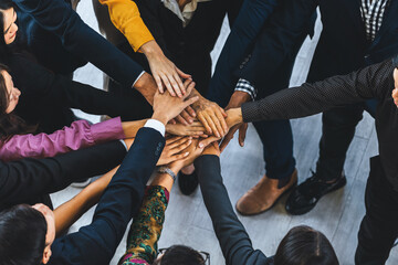 A group of diversity people putting their hands together. Showing unity teamwork and friendship. Close up top view of young business man and business woman joining as a team. Intellectual. - obrazy, fototapety, plakaty