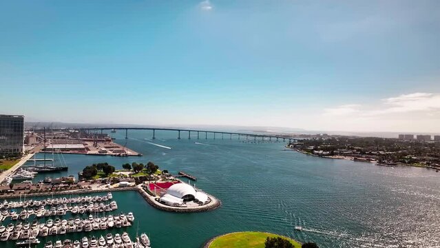 High aerial view of the Rady Shell and the San Diego Coronado Bridge with lots of boats in the harbor.