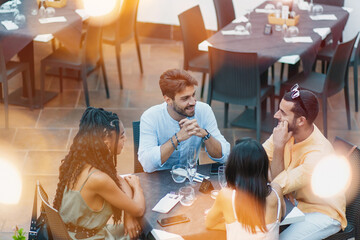 Outdoor dining with multicultural friends. - Multicultural group of friends gathers at an outdoor...