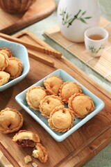 A crispy and crunchy snack shaped like a pastel cake with a small size and containing savory shredded beef