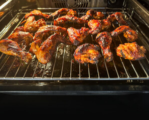 Grilling marinated chicken wings on grill in oven