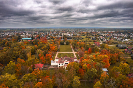 Aerial view of historic Rokiskis manor surrounded by colorful autumn forest