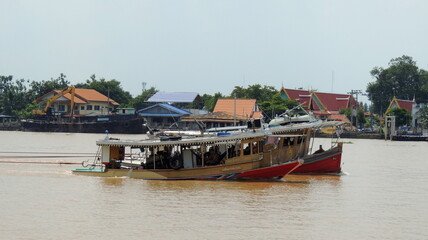 Fototapeta na wymiar Tugboat, Pusher, Pusher Craft, Pusher Boat, Pusher Tug, or Towboat Pulling Huge Barge at Chao Phraya River, Thailand