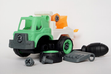 DIY plastic towing truck toy isolated on white background with bolt and screwdriver