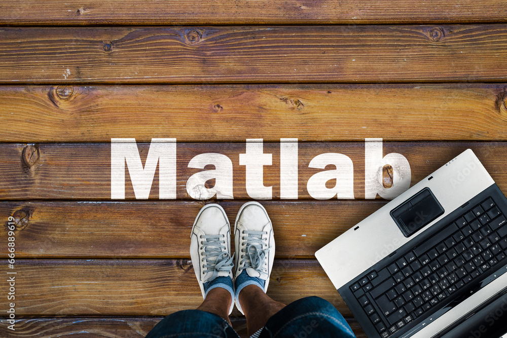 Poster Legs in sneakers standing next to laptop and Matlab on wooden floor. Matlab programming language. 
