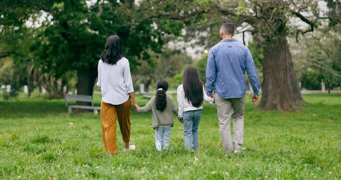 Family, park and parents walking with children for bonding, relationship and holding hands outdoors. Nature, back and mom, dad and kids on holiday, vacation and weekend for relax, fun and adventure