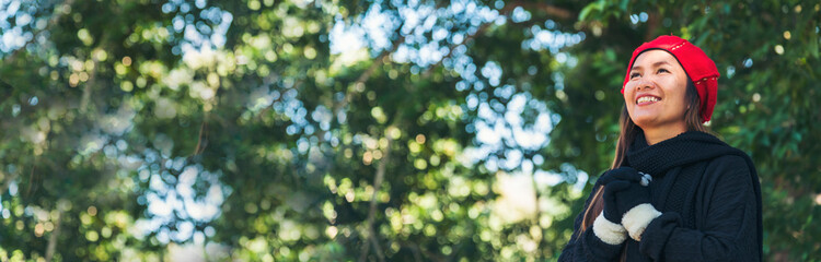 Banner Portrait Asian Woman relaxing in green park. Happy Relax asian woman smiling face at outdoors garden. Women enjoy nature freedom lifestyle. Greenery wellbeing outside in nature with copy space