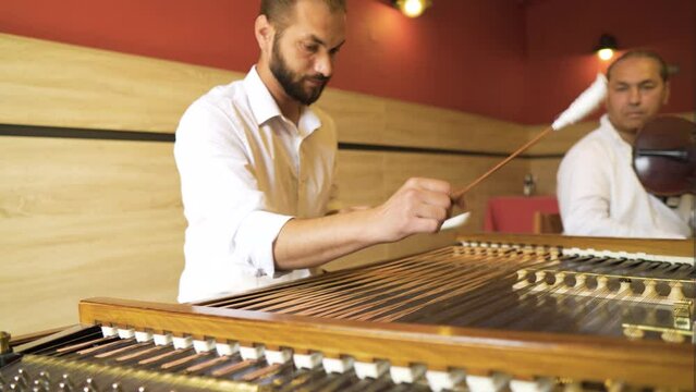 duo band group of professional musician players European Roma Gypsy men naturally talented skilful performing melodies tunes rooted in the culture hitting strings of instruments cimbalom violin wowsy