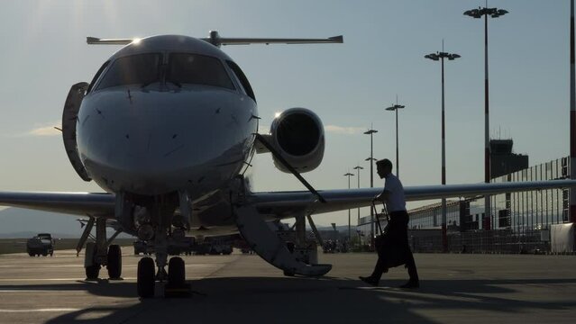 Pilot with Suitcase Walks Up Stairs to Enter Aircraft Static Slomo