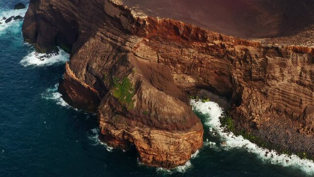 Aerial drone shot of majestic red colored volcanic coastline in the Azores Islands - Portugal.