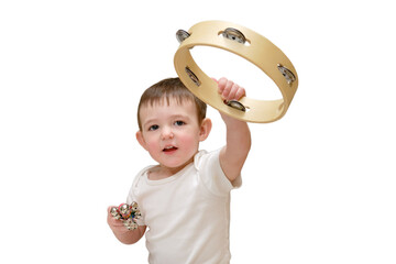 Toddler baby plays the tambourine while sitting on the floor in the children's room. Child boy...