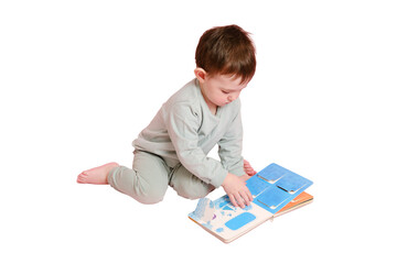 Happy toddler baby is reading a book on studio, isolated on white background. Child boy plays with...