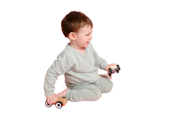 Happy toddler baby is playing with a toy car against a pink background, isolated on white...