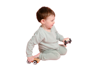 Happy toddler baby is playing with a toy car against a pink background, isolated on white background. Child boy rolls a wooden toy car. Kid age one year eight months, full height