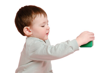 Happy toddler baby plays with cubes on studio, isolated on white background. Child boy builds a tower of toys, isolated on white background. Kid age one year eight months