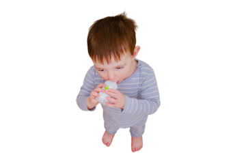 Toddler baby opened a cabinet drawer with pills and a vial of potion, isolated on white background. Child boy holding medicine bottle standing in home living room. Kid age one year nine months