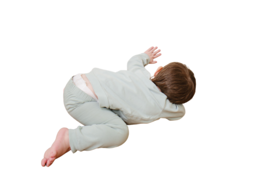 Little baby peeps under the door, isolated on white background. Small child looks through the crack of a closed door, isolated on white background. Kid aged two years
