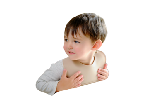 The child is impatiently waiting for food sitting at the table in a bib, isolated on white background. Kid boy aged two years (two-year-old)
