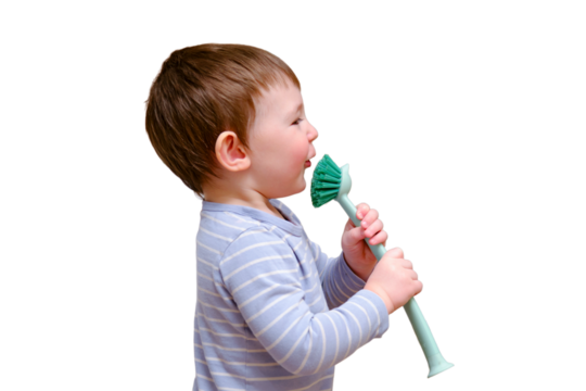 Happy toddler baby with a cleaning brush in the house, isolated on white background. A funny child is holding a large brush in his hands.