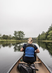 Fototapeta na wymiar blonde Girl Canoe ride exploring nature on morning mist Kejimkujik National Park Wilderness Nova Scotia Canada