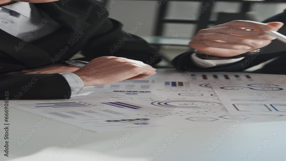 Poster vertical slowmo shot of two unrecognizable business partners actively involved in project discussion
