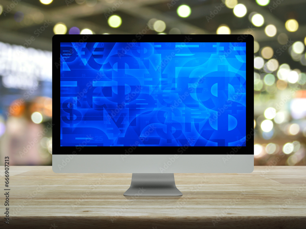 Aufkleber financial currency symbol on desktop computer monitor screen on wooden table over blur light and sha