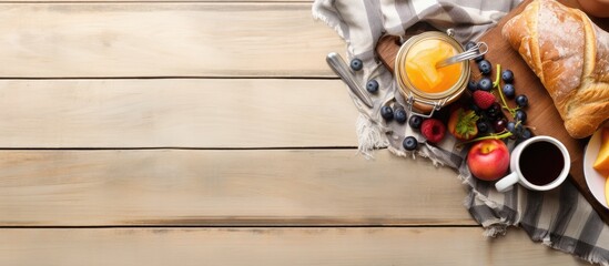 Top view of a breakfast scene with tablecloth fruits toast jam jar phone and cutting board